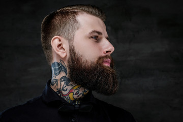 Wall Mural - Profile portrait of an expressive bearded man with tattoos on his neck