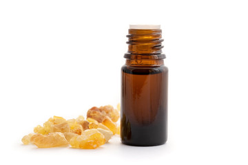 Wall Mural - A bottle of frankincense essential oil with frankincense resin on a white background