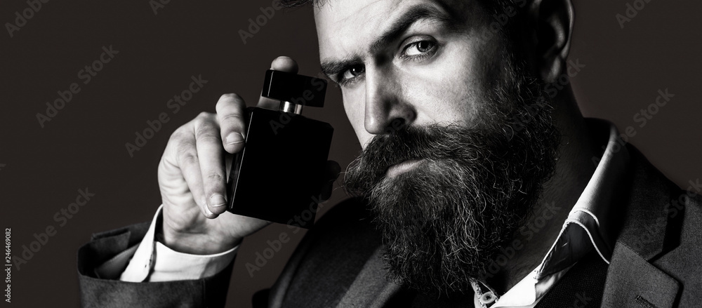 Man holding up bottle of perfume. Man perfume, fragrance. Fashion perfume bottle. Businessman likes perfume scent. - obrazy, fototapety, plakaty 