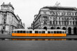 A picture of the typical yellow tram in Budapest, Hungary. The tram is isolated in the black and white background.