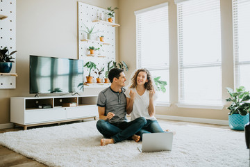 Happy Couple using Laptop at Home