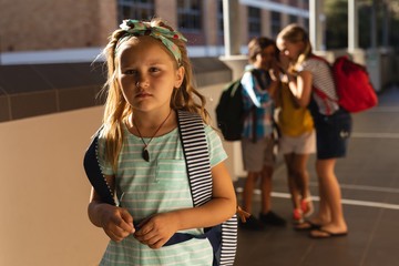 Wall Mural - School friends bullying a sad girl in hallway of elementary