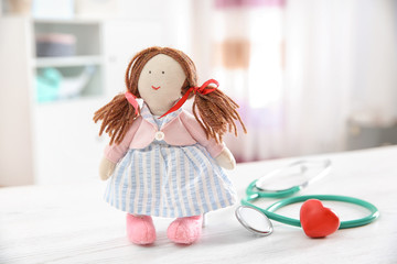 Wall Mural - Doll, stethoscope and heart on table indoors. Children's doctor