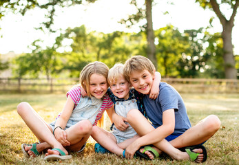 Wall Mural - Siblings putting their arms around each other