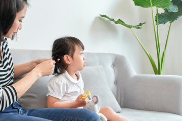 Wall Mural - mother braiding hair of her daughter