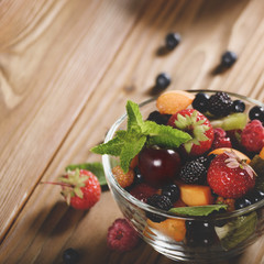 Wall Mural - Assorted fruits in glass bowl on kitchen wooden table