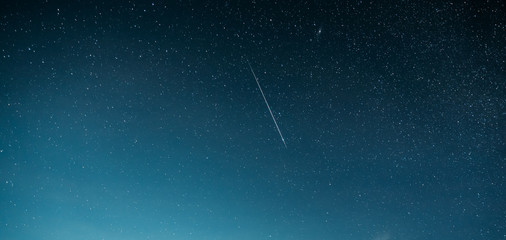 night starry sky with glowing stars and meteoric track trail. meteorite trail in starry sky backgrou