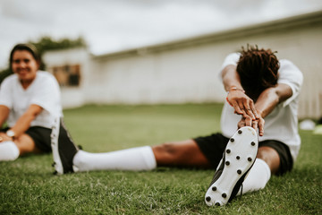 Canvas Print - Female football player stretching before a match