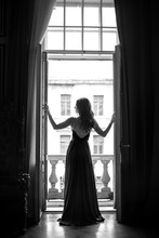 Black White Portrait Of Young Woman In Elegant Silk Black Dress Lookingto A City From A Balcony, Fashion Beauty Photo