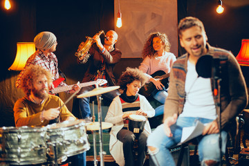 Canvas Print - Multicultural band practicing for the gig. Home studio interior.