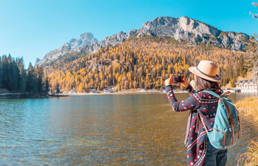 Traveler Woman use mobile phone to take amazing photos of a Misurina mountains lake