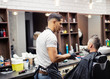 © Halfpoint - Rear view of man client visiting haidresser and hairstylist in barber shop.