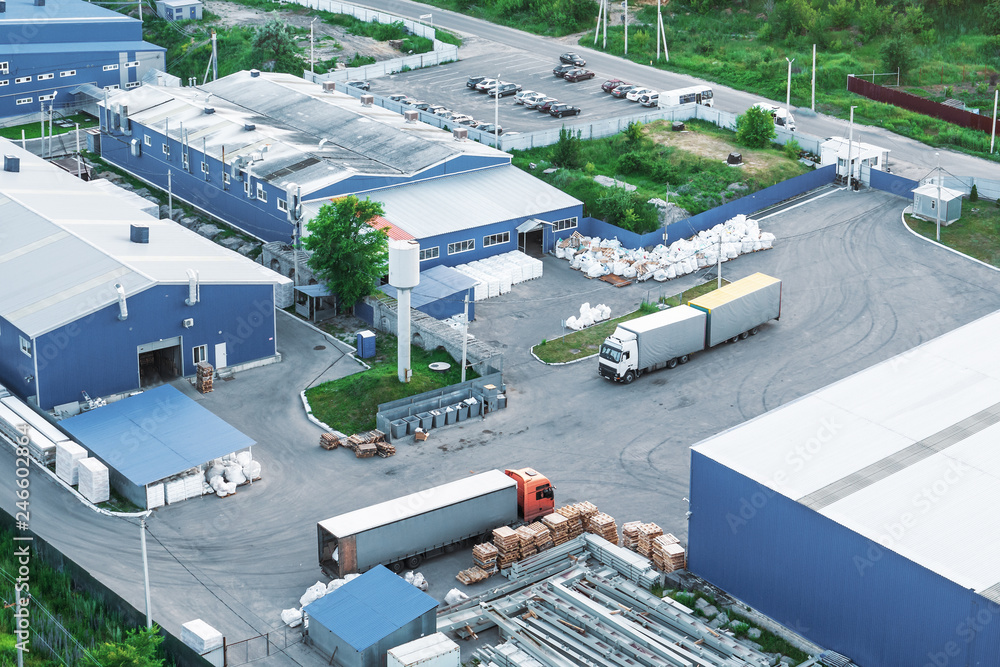 Aerial view from above of industrial buildings, warehouses or factory storages or logistic company with trucks and goods - obrazy, fototapety, plakaty 