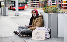 Homeless Beggar Man Sitting Outdoors In City Asking For Money Donation.