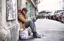 Homeless Beggar Man Sitting Outdoors In City Asking For Money Donation.