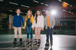 Cute smiling children in roller skates standing on spacious roller rink