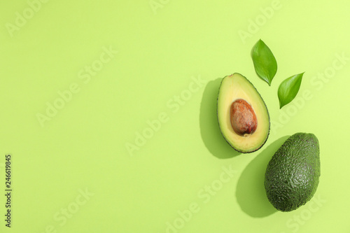 Cuadros en Lienzo Ripe sliced avocado with green leaves, top view