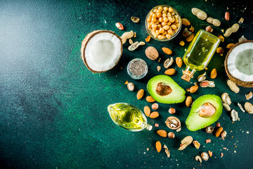 Wall Mural - Healthy vegan fat food sources, omega3, omega6 ingredients - almond, pecan, hazelnuts, walnuts, olive oil, chia seeds, avocado, coconut,  banner copy space