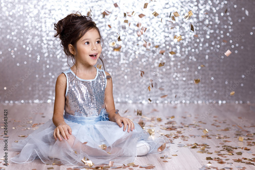 little girl in blue dress sitting on the floor with confetti Stock ...