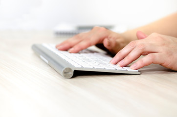 Female hands on wireless keyboard, closeup