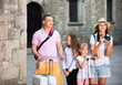 © JackF - Tourist family using map and taking photo of city while strolling