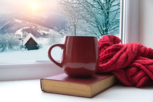 Winter Background - Cup With Candy Cane, Woolen Scarf And Gloves On Windowsill And Winter Scene Outdoors. Still Life With Concept Of Spending Winter Time At Cozy Home With Cold Weather Outdoors