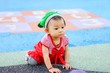 © waridsara - A baby child girl crawling on a flexible floor at the playground.