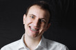 © Aleksandr - Portrait of a man of Caucasian appearance in orthodontic braces, metal brackets on his teeth in a white shirt on a black background. Dental concept, medicinal alignment of teeth orthodontist.