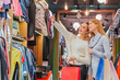 © Andrii - Young girls buying a lot of things in the store keep shopping bags.