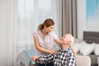 © New Africa - Elderly man with female caregiver at home. Space for text