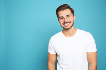 Canvas Print - Portrait of young man laughing on color background. Space for text