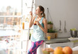 Young woman in fitness clothes having healthy breakfast at home