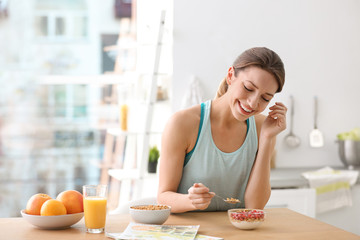 young woman in fitness clothes having healthy breakfast at home