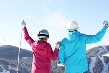 Couple with ski equipment spending winter vacation in mountains