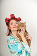 Housewife in curlers with a cat in her arms