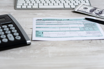 US tax form 1040 with pen, calculator and dollar bills. tax form law document usa white business concept