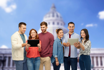 Sticker - friendship and people concept - group of smiling friends with tablet computers over capitol building background