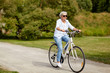 © Syda Productions - active old age, people and lifestyle concept - happy senior woman riding fixie bicycle at summer park