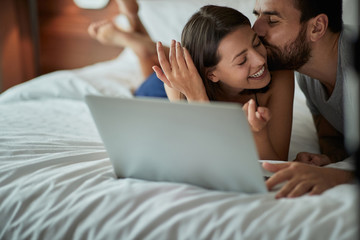 Wall Mural - Happy in bed – couple enjoying and kissing in the bed.