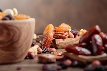 Various dried fruits and nuts in wooden dish.