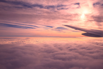 Clouds view from the airplane, Flying over the evening timelapse clouds with the late sun. Flight through moving cloudscape with beautiful sun rays. . Perfect for cinema, Pink background