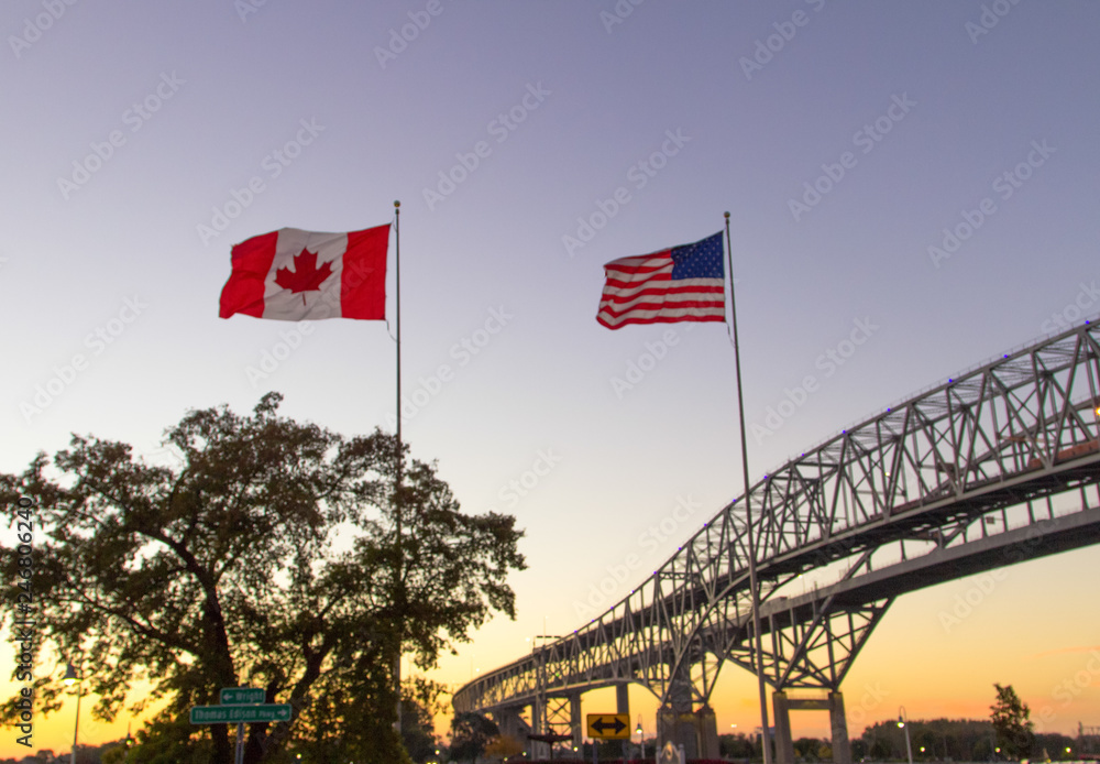 International Border Crossing. Sunset at the Blue Water Bridge border United States and Canada crossing. The bridge connects Port Huron, Michigan and Sarnia, Ontario. - obrazy, fototapety, plakaty 