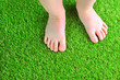 © Dmytro - Artificial turf background. Tender foots of a baby on a green artificial grass floor.