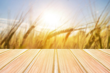 Wall Mural - Empty wooden table with blurred grasses, grain on background, wheat,barley, rye.Summer, spring background