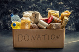 Fototapeta Tulipany - Donation box full of different products on dark background
