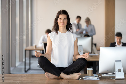Calm Young Business Woman Doing Yoga Exercise At Workplace Sitting