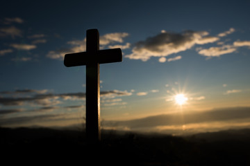 Silhouette of catholic cross and sunrise