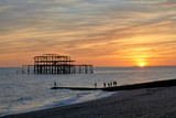 Fototapeta  - The ruins of Brighton's West pier silhouetted against a setting sun.