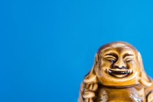 Generic Statue Of Laughing Buddha On Sky Blue Background. Buddhism Religious Symbol. Zen Tranquility Harmony Concept. Minimalist Inspirational Image With Copy Space For Quotes.