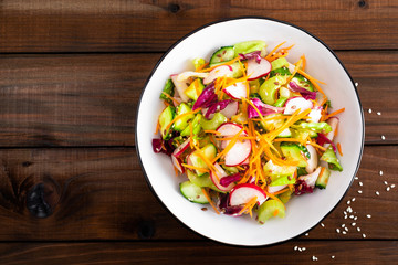 Poster - Healthy vegetarian vegetable salad with fresh raw radish, carrot, celery, lettuce, sesame and flax seeds. Vegan diet food